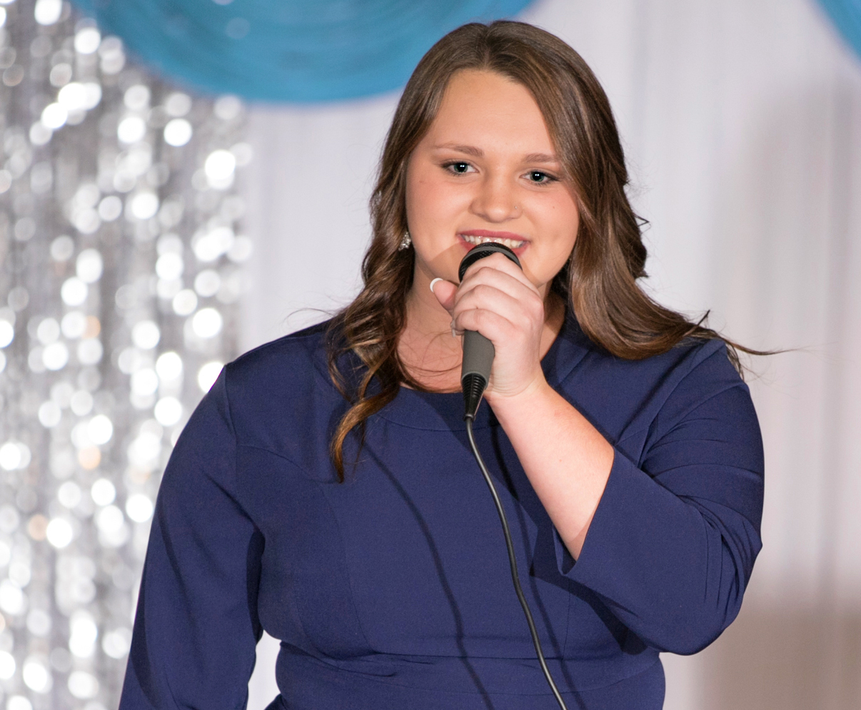 Young girl anwering pageant on-stage question.